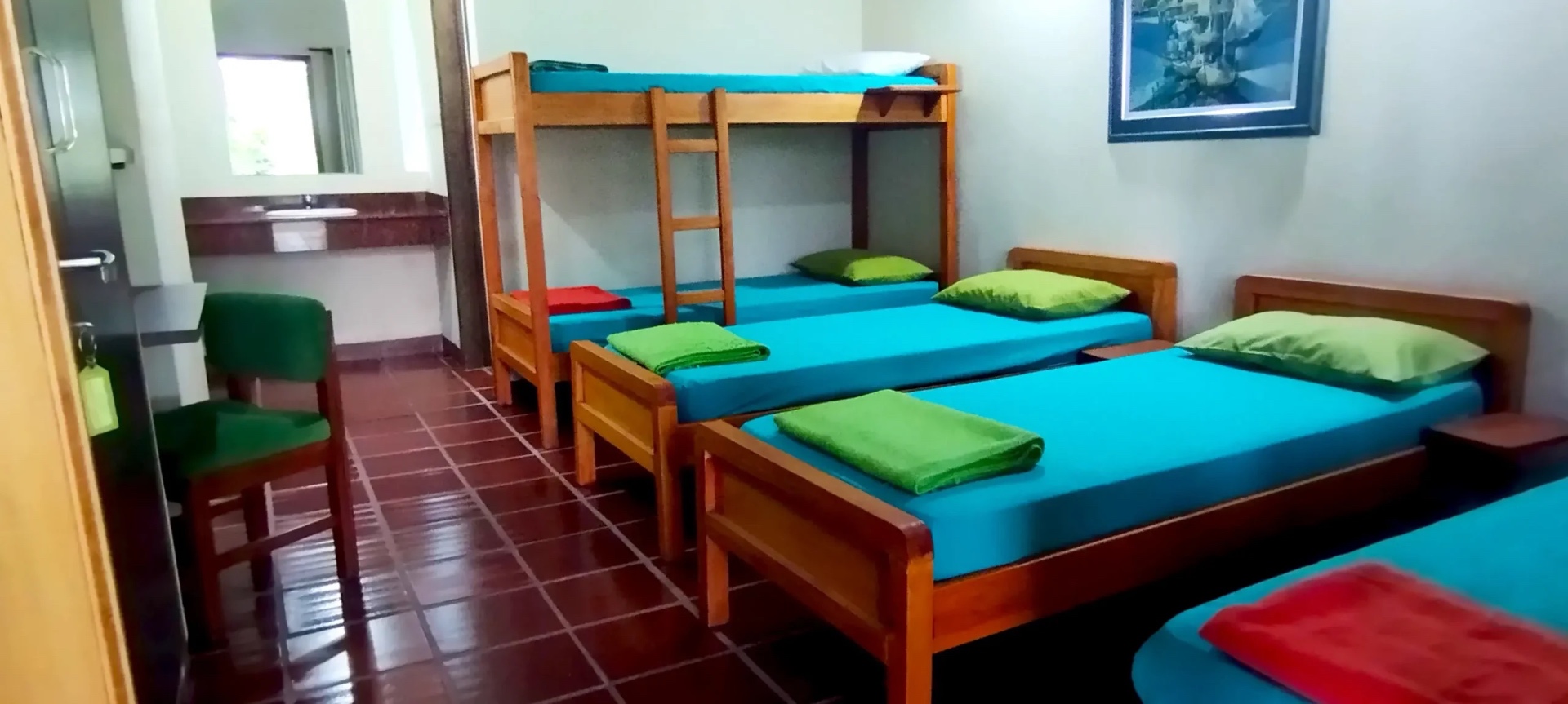 Habitación con literas y sábanas turquesas